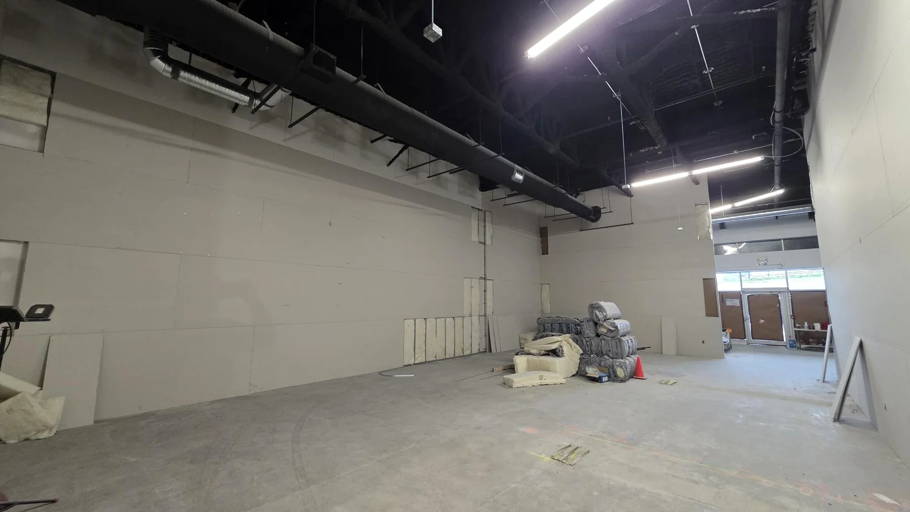 Boarded interior partitions during the Club Champion retail tenant improvement. Boarded interior partitions during the Club Champion retail tenant improvement.