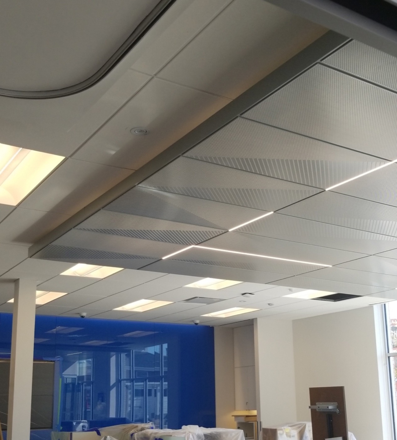 Curved suspended ceiling feature with acoustic panels in a completed commercial interior. Curved suspended ceiling feature with acoustic panels in a completed commercial interior.