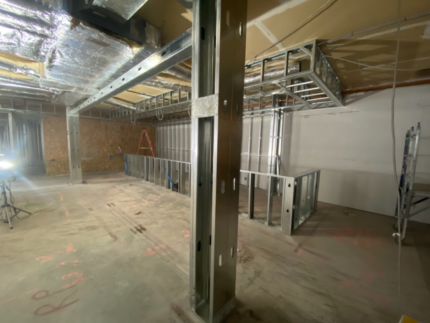 Commercial steel stud partitions with drywall installation in progress around existing columns. Commercial steel stud partitions with drywall installation in progress around existing columns.