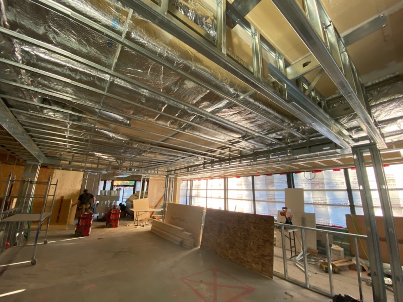 Commercial interior with overhead steel stud ceiling framing and building services in progress. Commercial interior with overhead steel stud ceiling framing and building services in progress.